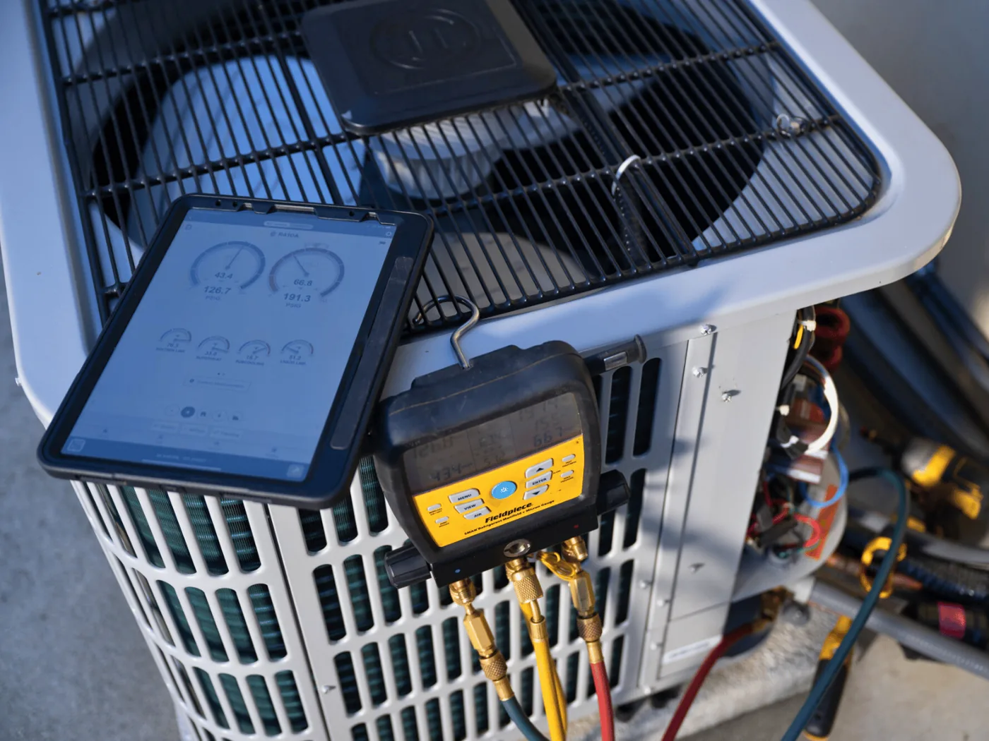 Tablet running measureQuick at an outdoor condenser, reading wireless probes on the service ports with no manifold connected