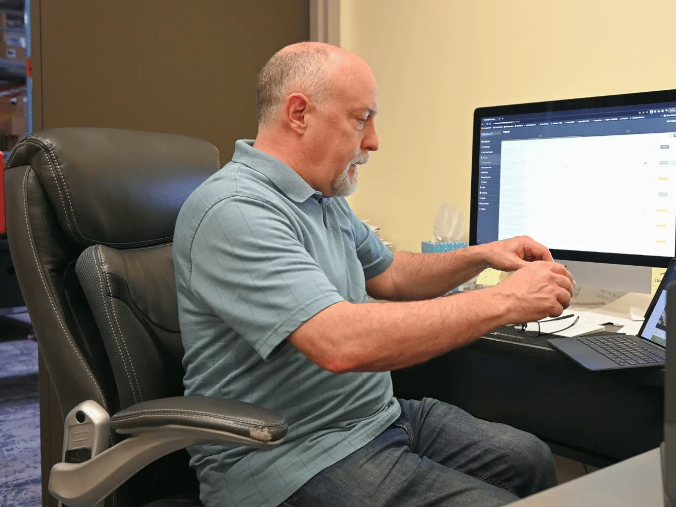 A service manager at an office monitor reviewing measureQuick commissioning results across the team’s jobs in the cloud