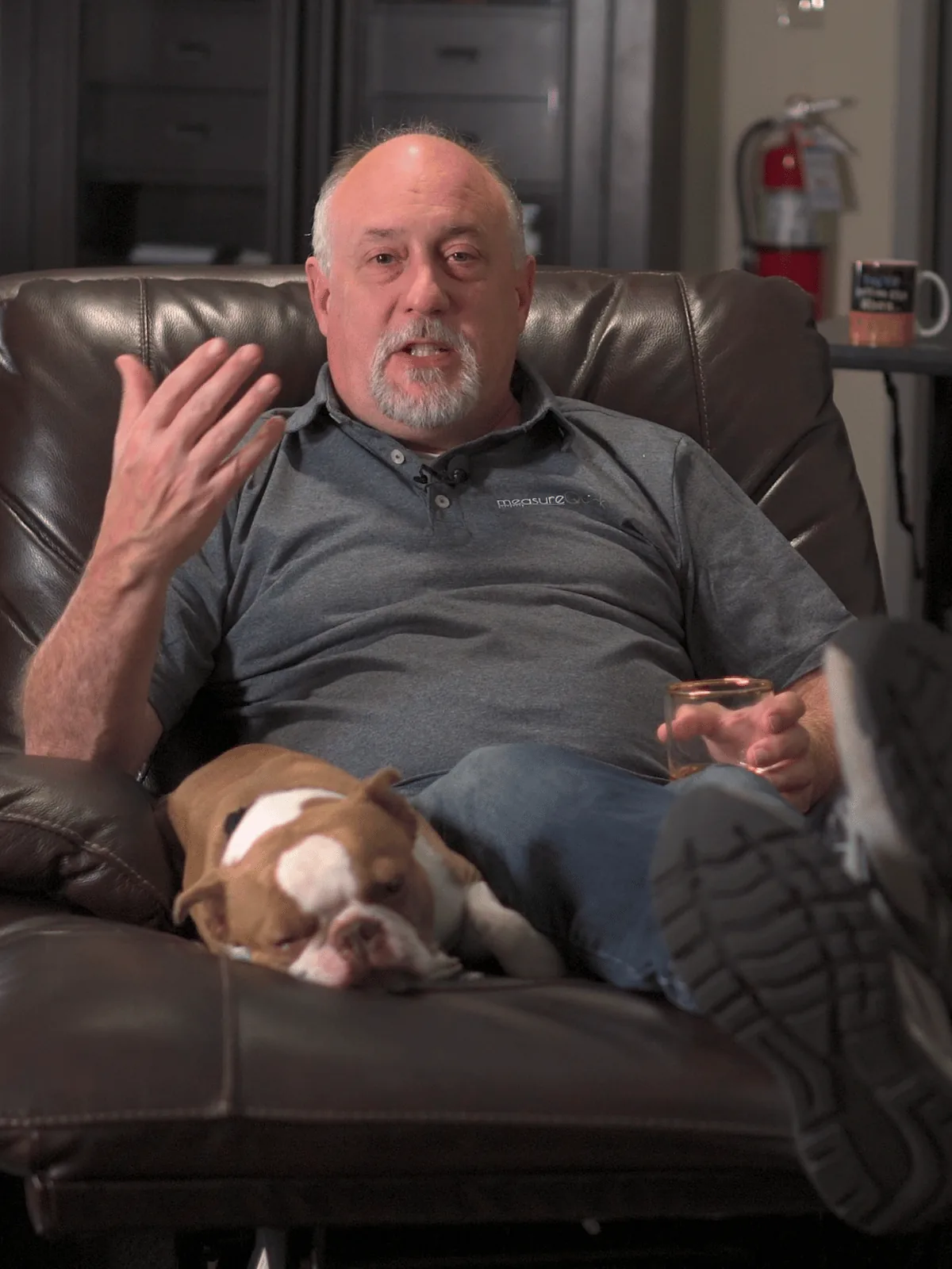 Jim Bergmann, measureQuick founder, in a measureQuick shirt with his bulldog beside him