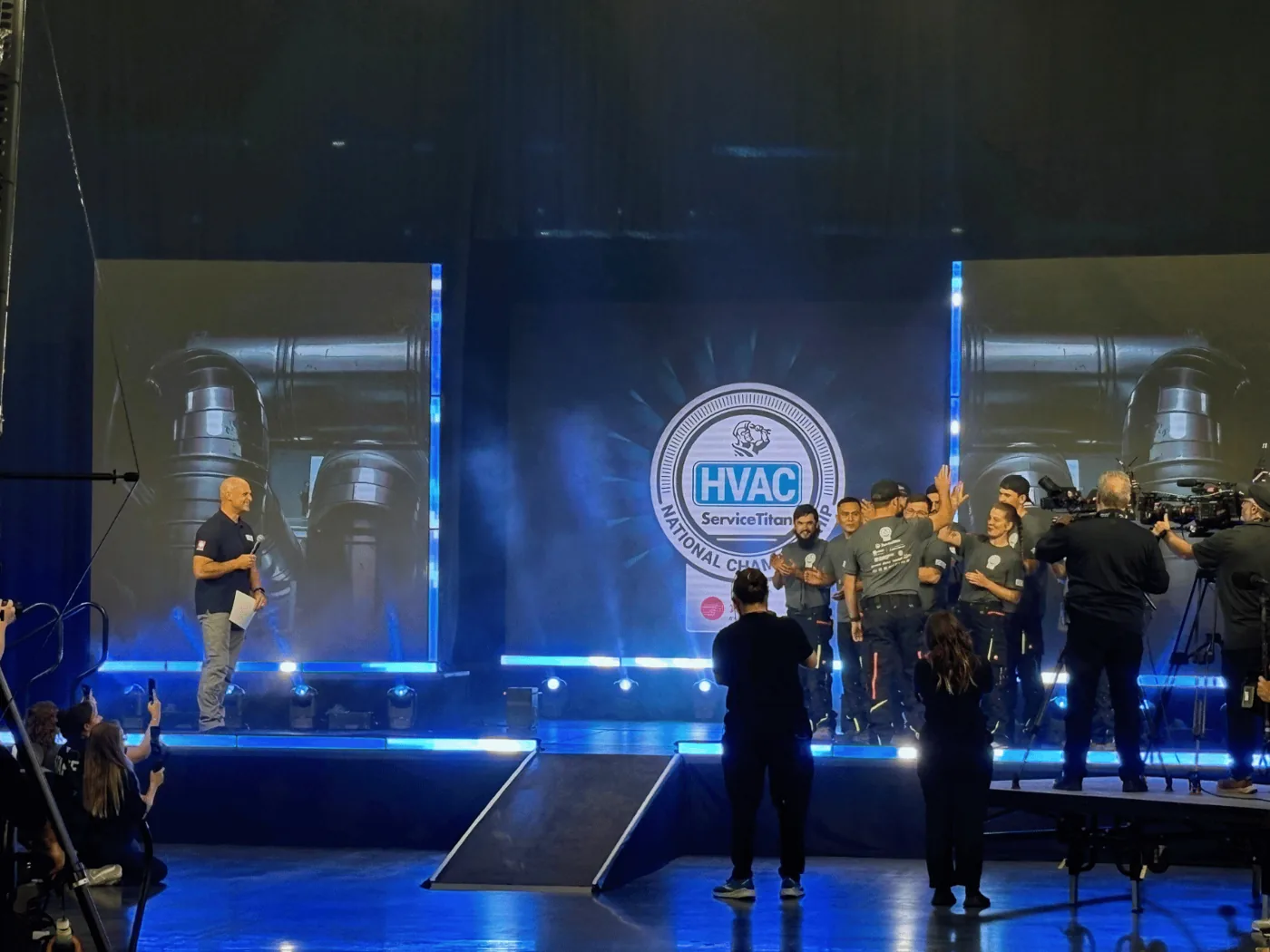 Competitors on stage at the 2025 ServiceTitan HVAC National Championship, where measureQuick training units were the competition platform
