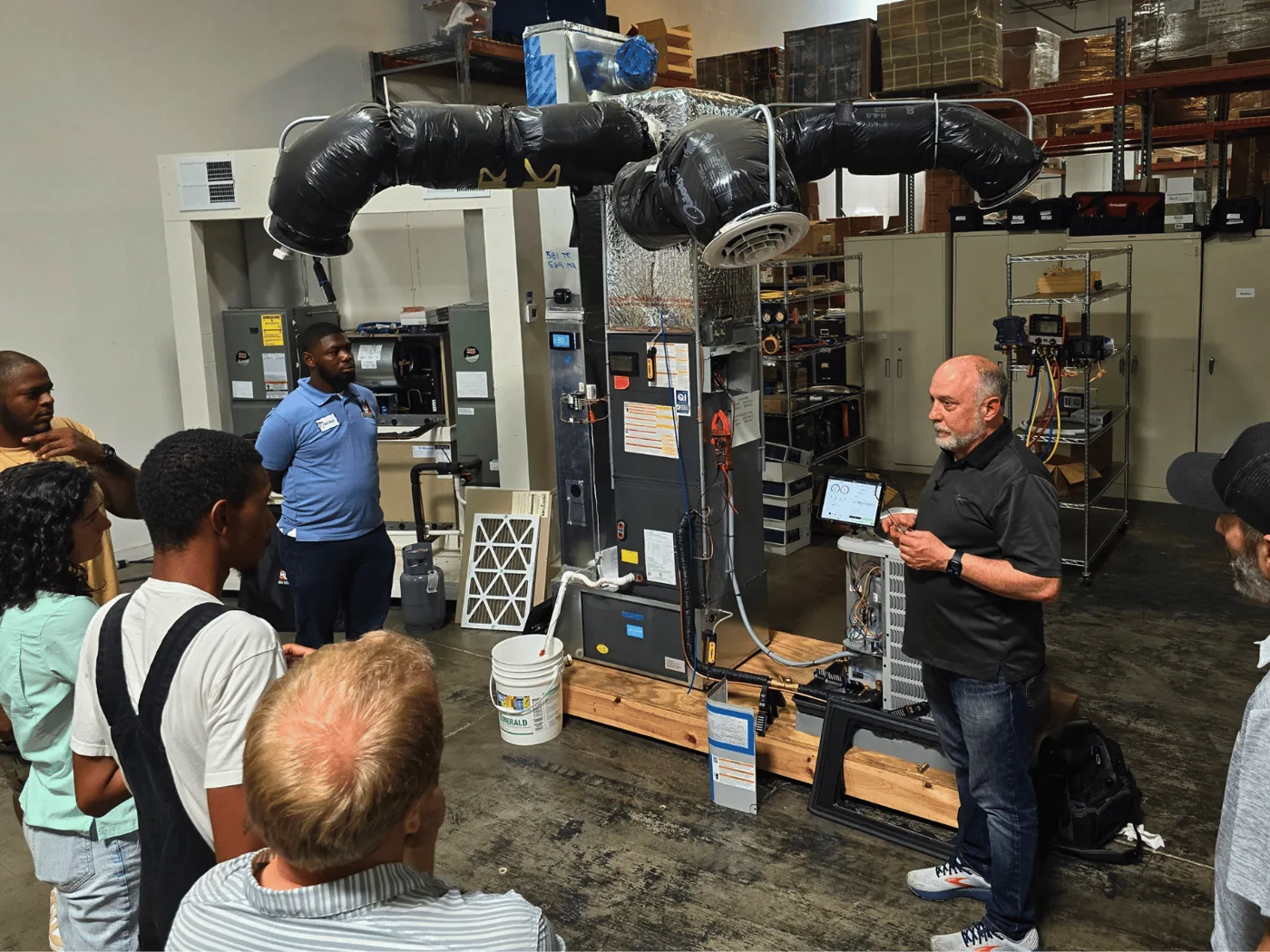 A measureQuick trainer teaching a class on a fully functional HVAC training unit in the lab