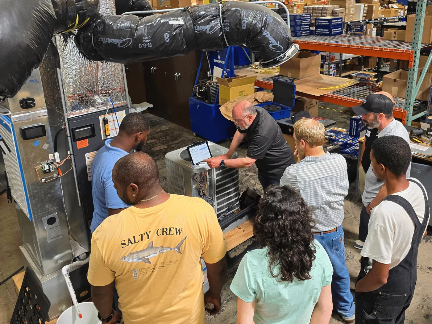 A measureQuick trainer walks a class through a live diagnostic on an outdoor condenser with a tablet in hand