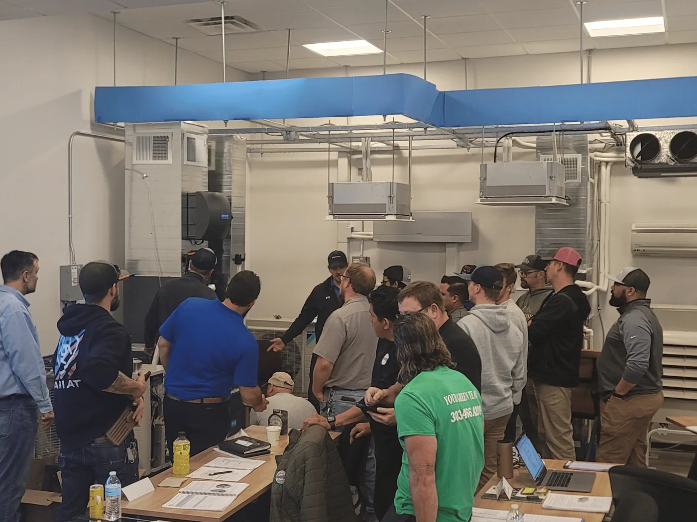 A full class gathered around a ducted lab system during a measureQuick training session