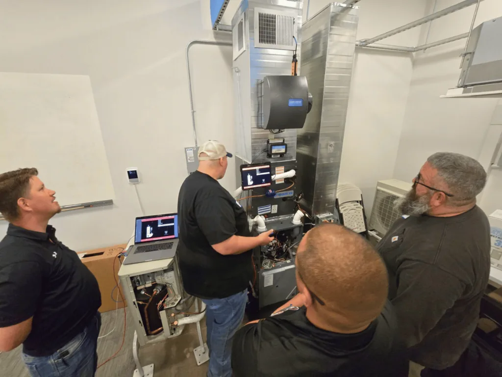 Technicians gathered around a measureQuick training unit running a live diagnostic
