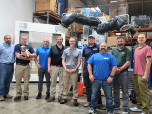 a group of men standing in a room with a dog